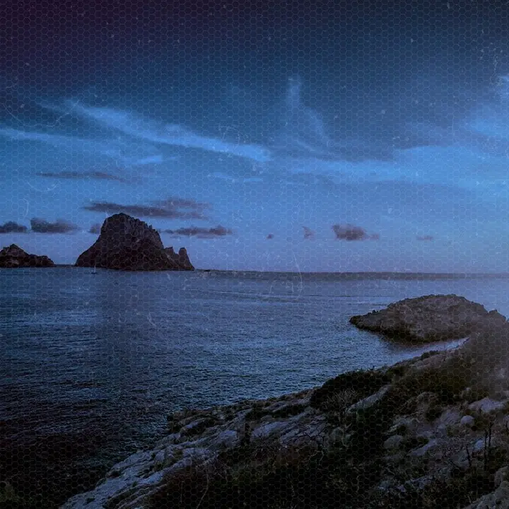 Es Vedra rising from the sea off Ibiza at dusk